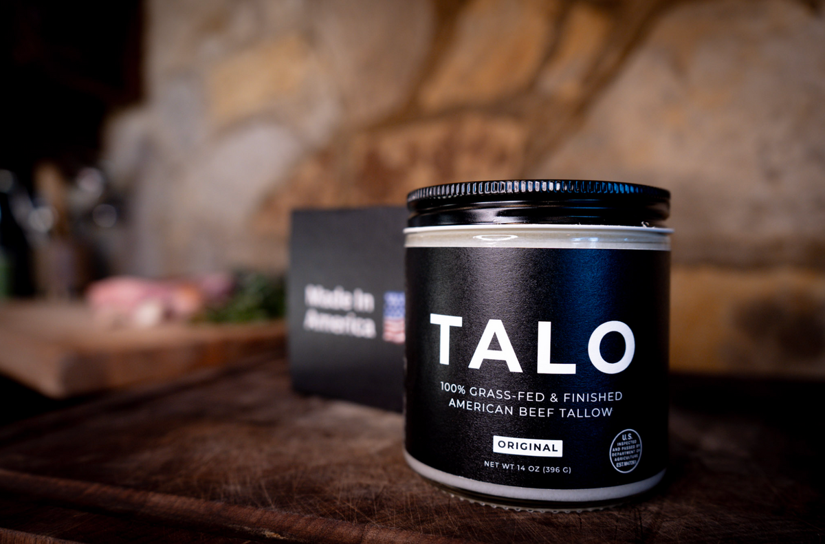 TALO grass-fed American beef tallow jar with a Made in America card on a rustic counter
